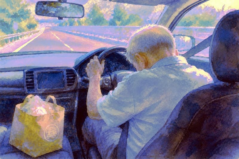 居眠り運転する高齢者。隣には饅頭の袋がある。